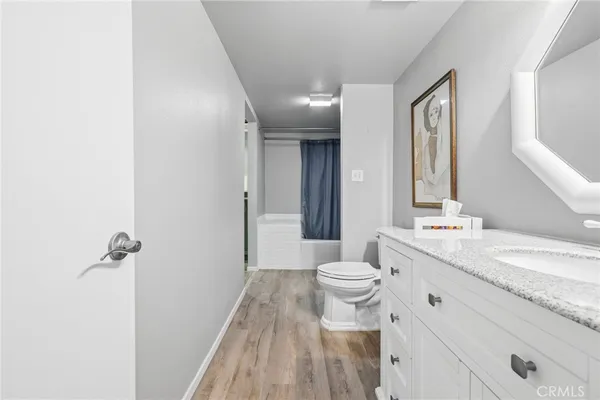 a bathroom with a granite countertop sink a toilet and a mirror