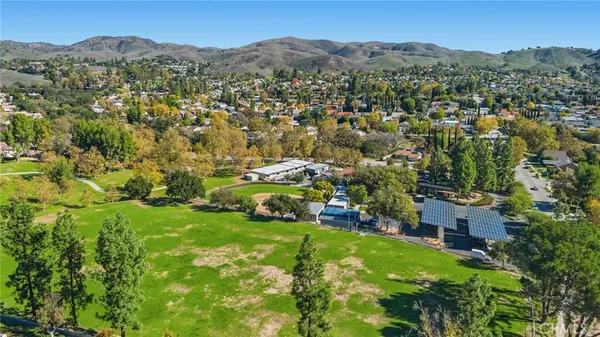an aerial view of residential houses with outdoor space and trees
