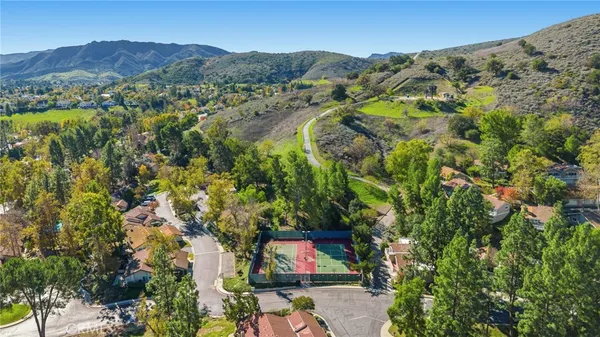 an aerial view of residential houses with outdoor space and trees