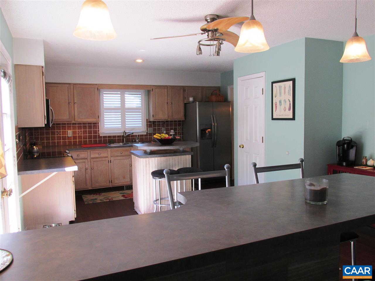 2704 Huntington Road Charlottesville, VA 22901 - Photo 7 of 42 a kitchen with a table chairs refrigerator and microwave