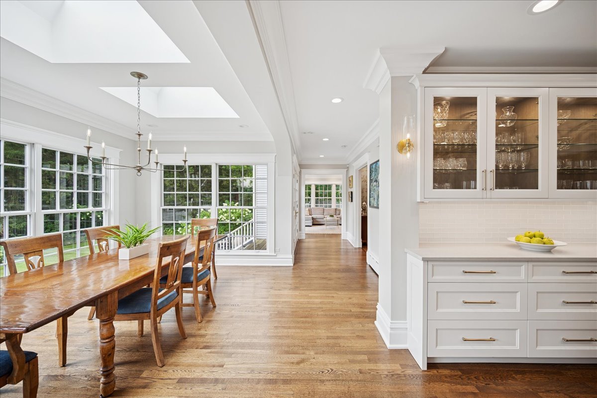 755 Lincoln Avenue Winnetka, IL 60093 - Photo 18 of 52 a dining room with wooden floor a chandelier a wooden table and chairs