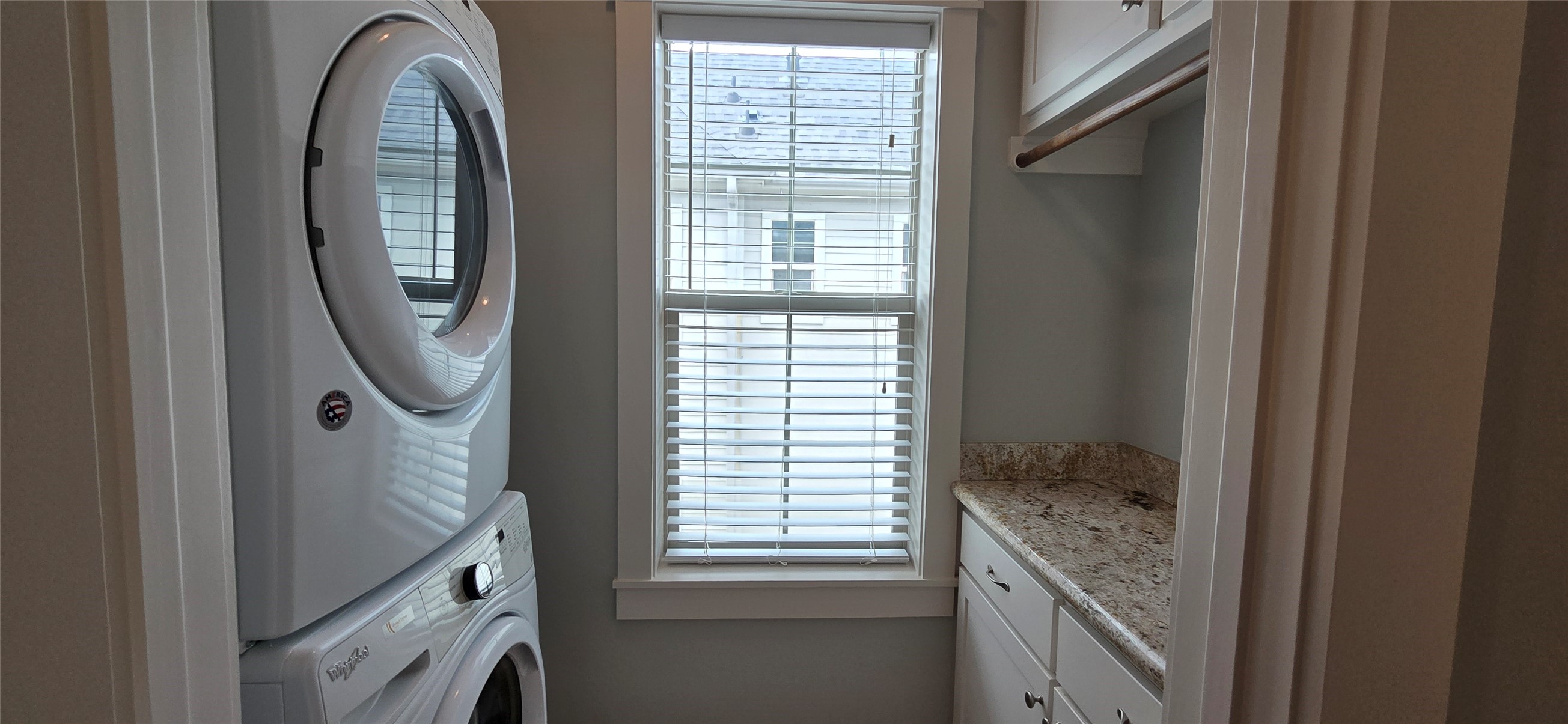 1117 Bonner Street Houston, TX 77007 - Photo 24 of 44 Utility room includes a stacked full size washer and dryer, a window for natural light, a granite countertop, a hanging rack for clothes and built-in cabinets and drawers for storage.