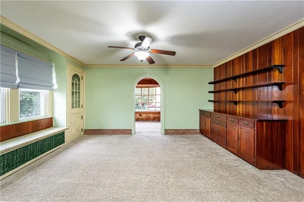 a view of an empty room with cabinet wooden floor and window