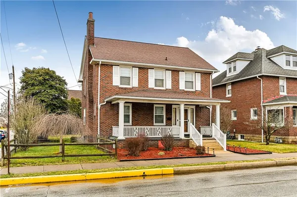 a front view of a house with swimming pool and porch