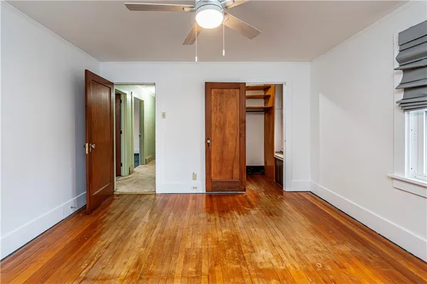 an empty room with wooden floor and closet