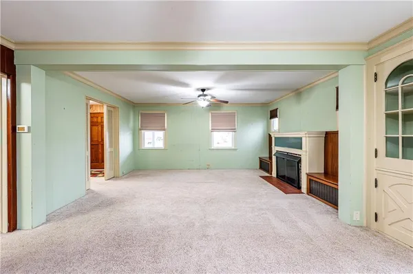 a view of an empty room with a fireplace and a window