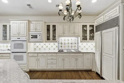 a kitchen with stainless steel appliances granite countertop a refrigerator and cabinets