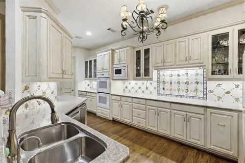 a kitchen with stainless steel appliances granite countertop a sink a stove and cabinets