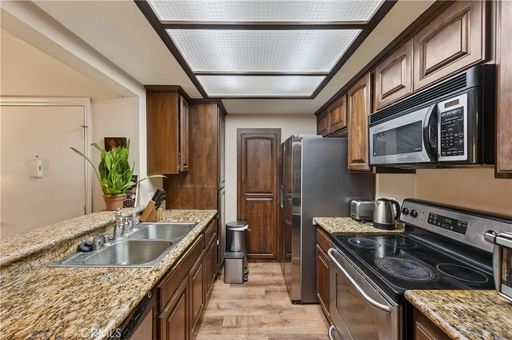3535 Banbury Drive, Unit 94 Riverside, CA 92503 - Photo 8 of 21 a kitchen with stainless steel appliances granite countertop a sink stove and refrigerator
