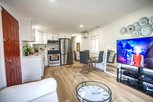 a living room with furniture a flat screen tv and a table