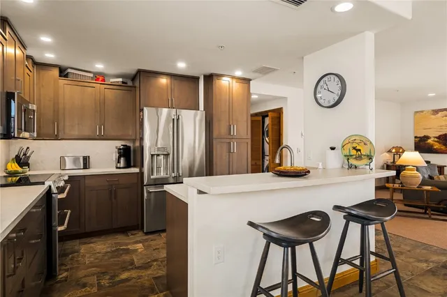 a kitchen with stainless steel appliances granite countertop a sink a stove and a refrigerator