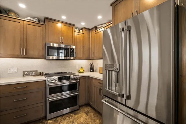 a kitchen with kitchen island a counter top space stainless steel appliances and cabinets