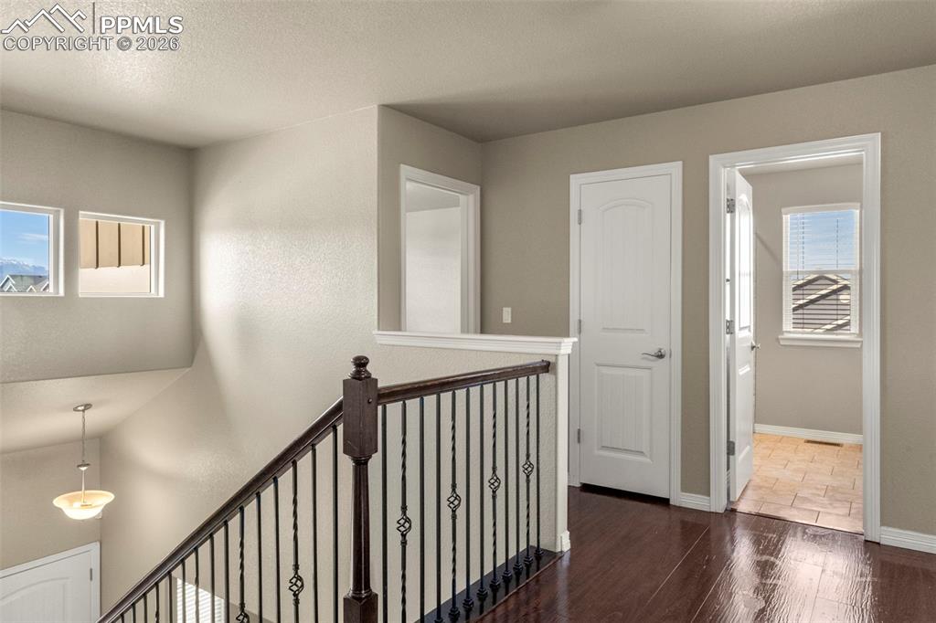 6105 Fiddle Way Colorado Springs, CO 80925 - Photo 14 of 40 a view of a hallway with wooden floor and stairs