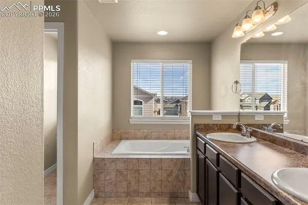 a bathroom with a granite countertop sink a large mirror and a bathtub