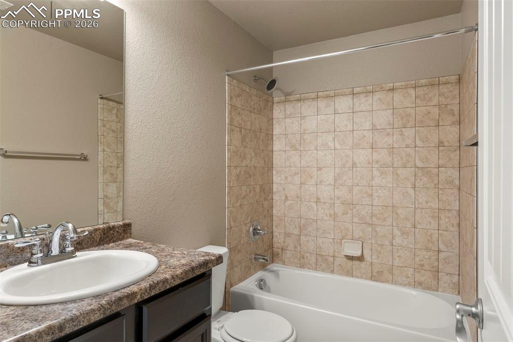 6105 Fiddle Way Colorado Springs, CO 80925 - Photo 29 of 40 a bathroom with a granite countertop sink toilet and shower