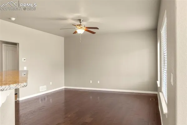 en empty room with windows and ceiling fan