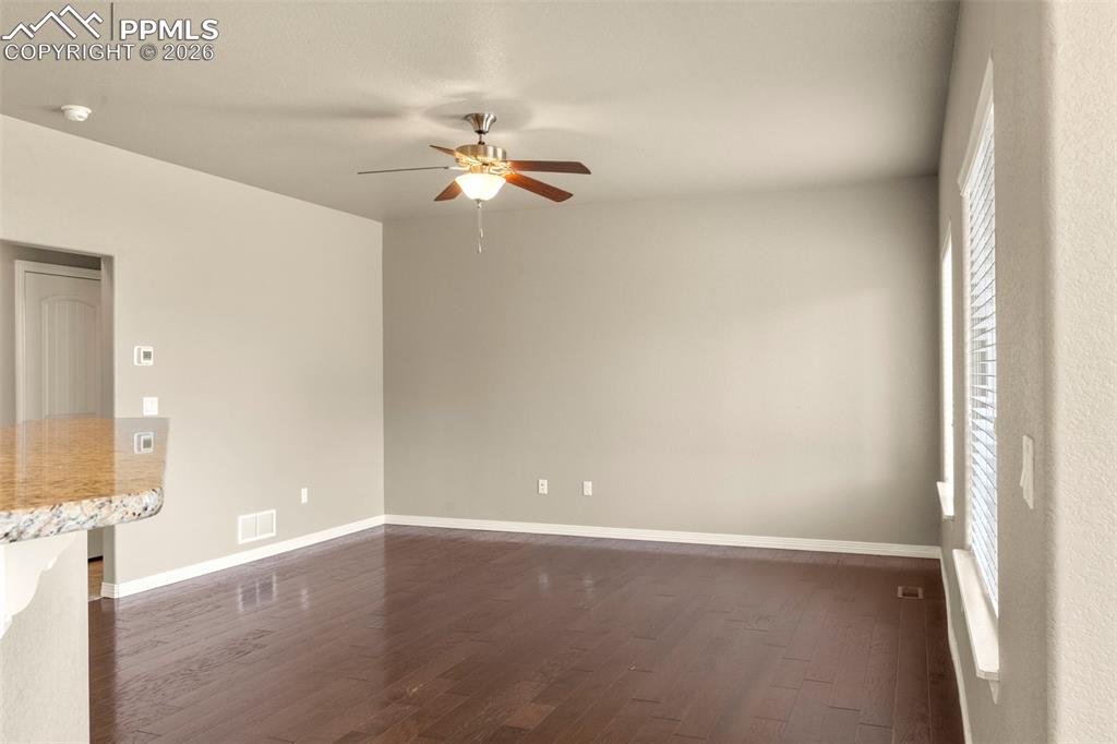 6105 Fiddle Way Colorado Springs, CO 80925 - Photo 7 of 40 en empty room with windows and ceiling fan