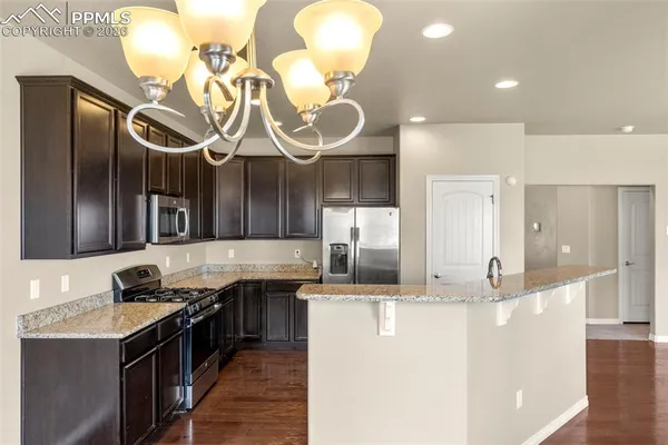 a kitchen with stainless steel appliances granite countertop a sink and a stove