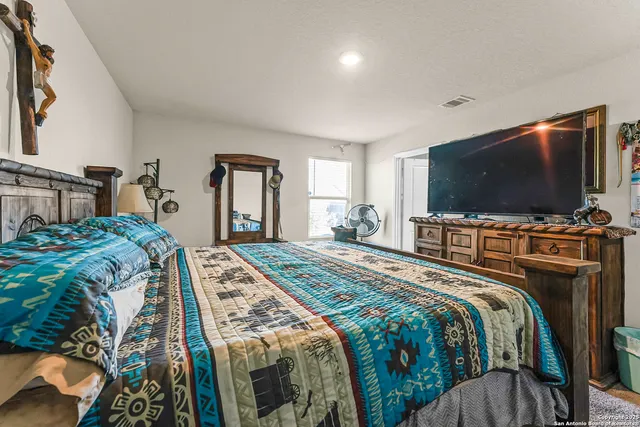 a bedroom with a bed and a flat screen tv