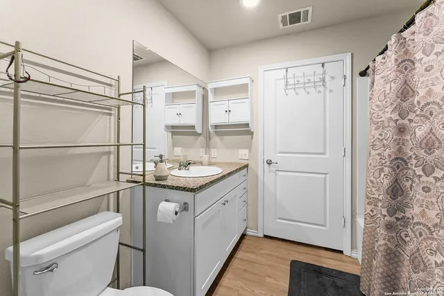 a bathroom with a granite countertop sink toilet and shower