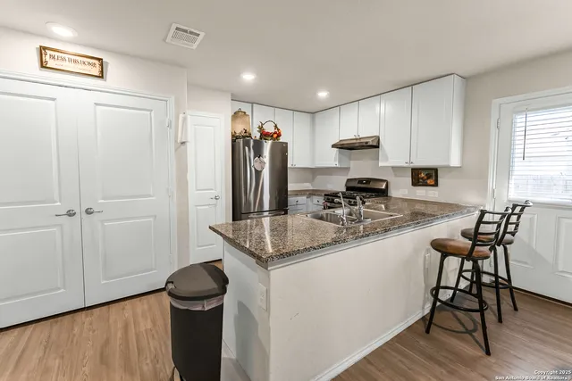 a kitchen with stainless steel appliances granite countertop a sink stove and refrigerator