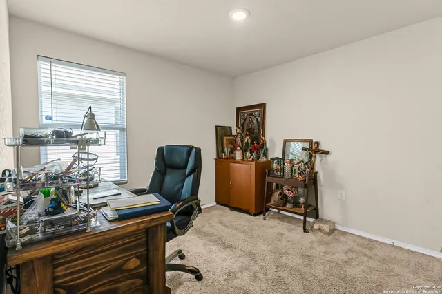 a view of a workspace with furniture and a window