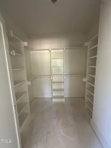 a view of walk in closet with empty racks