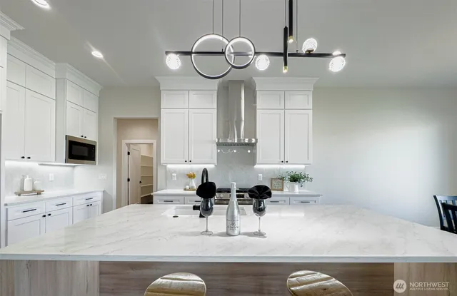 a kitchen with kitchen island granite countertop a sink a stove and cabinets