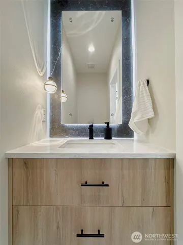 a large bathroom with a double vanity sink a large mirror and a bathtub