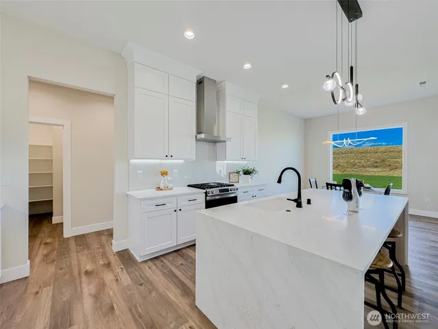 a kitchen with a sink stainless steel appliances and white cabinets