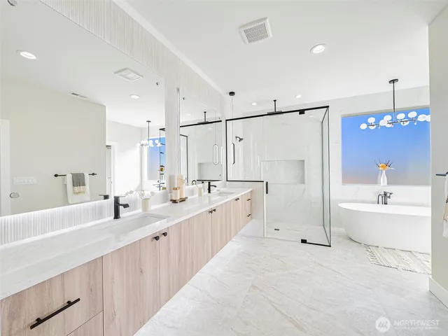 a large bathroom with a double vanity sink a large mirror and a bathtub