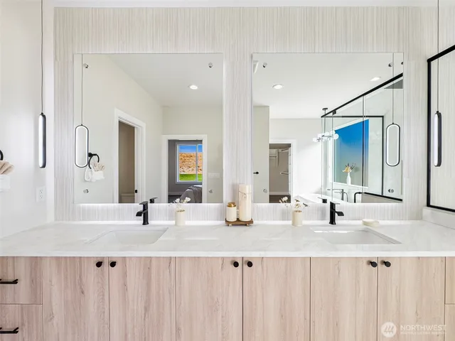 a bathroom with double vanity and a mirror
