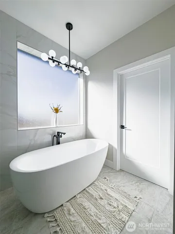 a spacious bathroom with a bathtub and chandelier