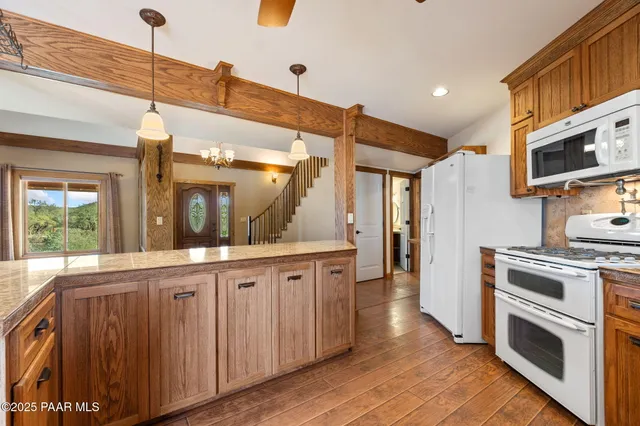 a kitchen with stainless steel appliances granite countertop a sink stove and wooden cabinets