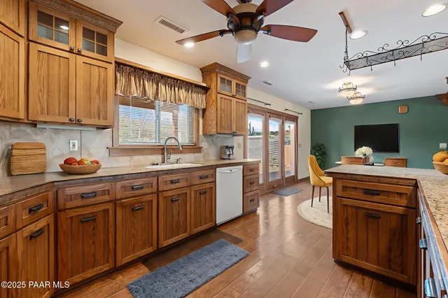 a view of a livingroom with a ceiling fan & windows
