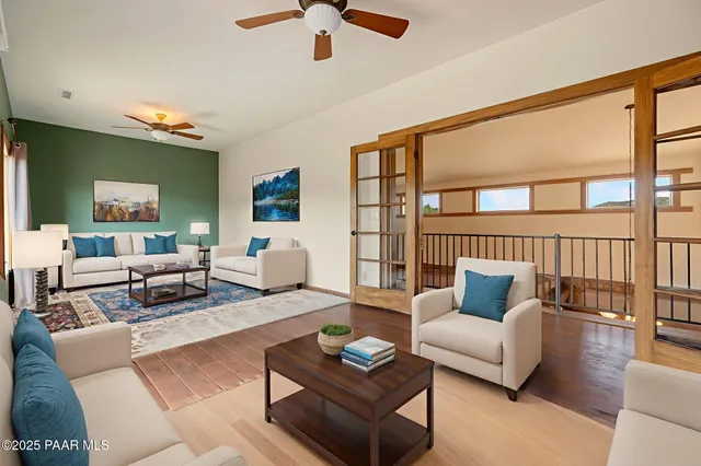 a view of a patio with couches chairs potted plants and a large tree
