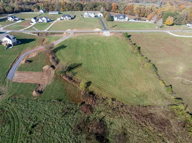 an aerial view of a house with a yard and lake view