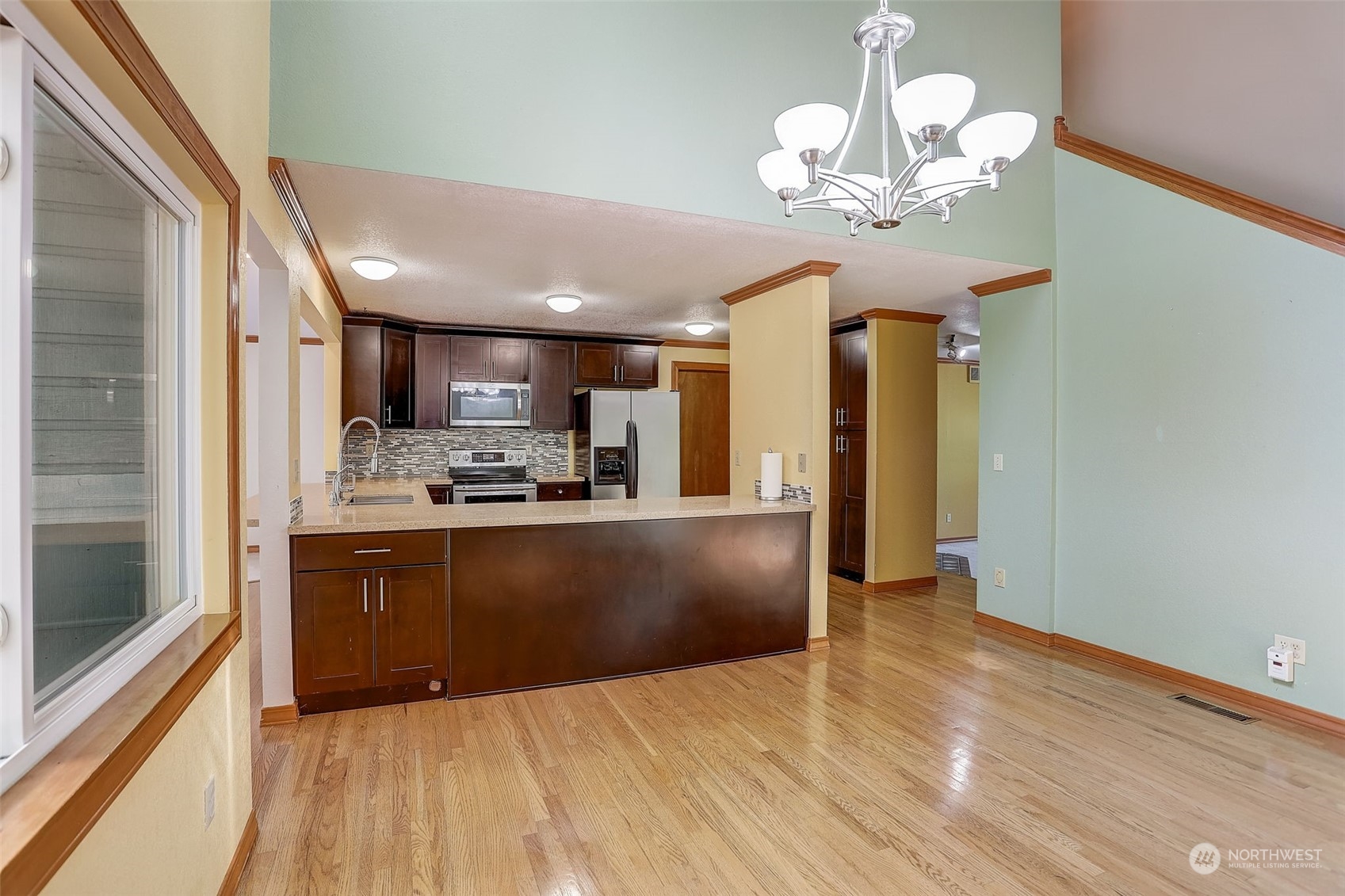 18600 East Spring Lake Drive Southeast Renton, WA 98058 - Photo 12 of 39 a large kitchen with stainless steel appliances granite countertop a refrigerator a stove and a sink with wooden floor