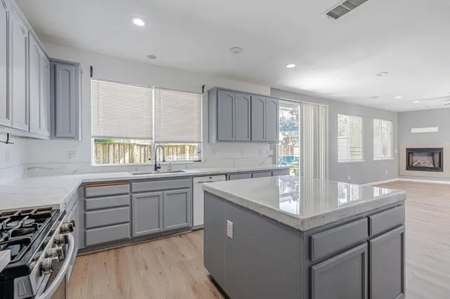 a kitchen with granite countertop a sink stove and cabinets
