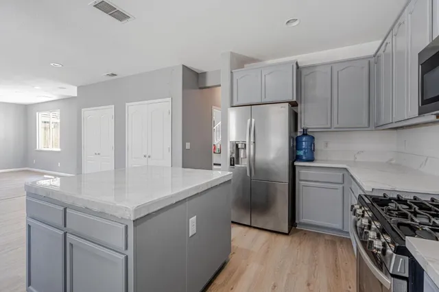 a kitchen with kitchen island a sink stove and refrigerator