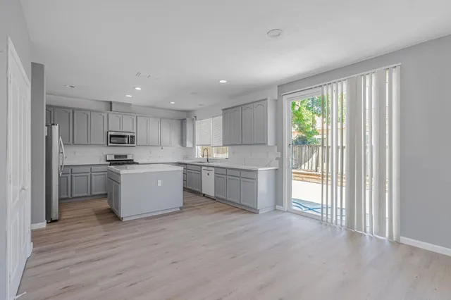 a kitchen with a refrigerator sink and cabinets
