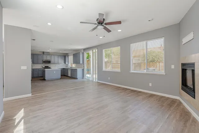 a view of empty room with windows and ceiling fan