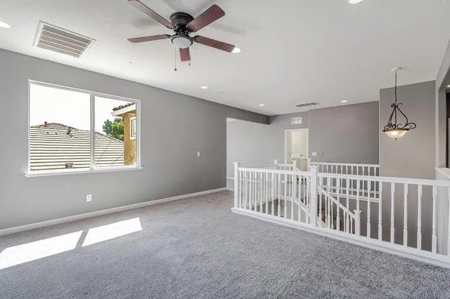 a view of a livingroom with a ceiling fan and window