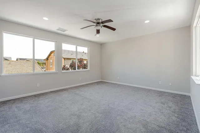 an empty room with window and ceiling fan