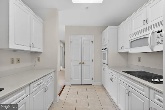 a kitchen with white cabinets and appliances