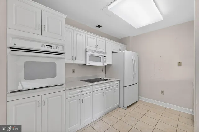 a kitchen with white cabinets and white appliances