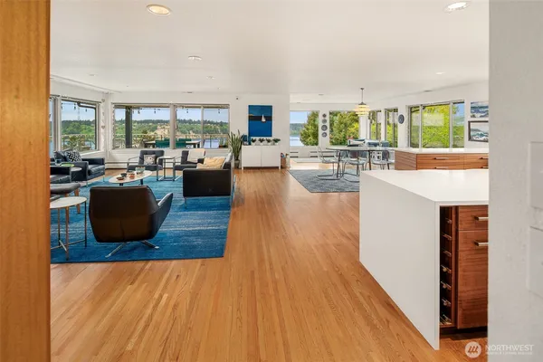 a living room with furniture a large window and wooden floor
