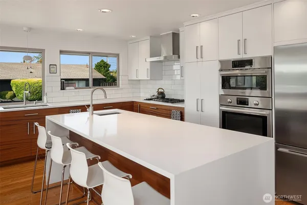 a kitchen with kitchen island a sink and appliances