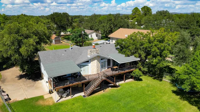 an aerial view of a house with swimming pool and garden