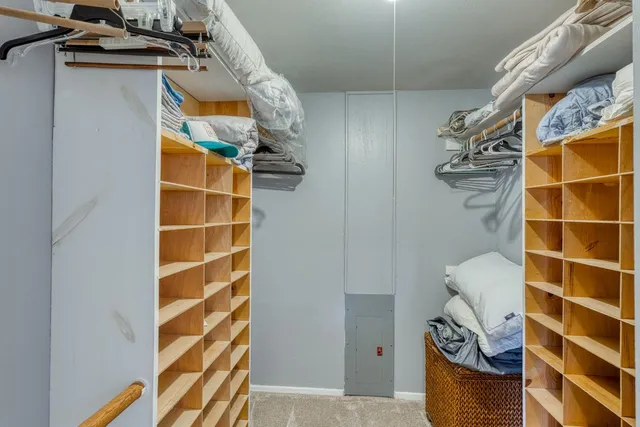 a view of walk in closet with clothes and shoes
